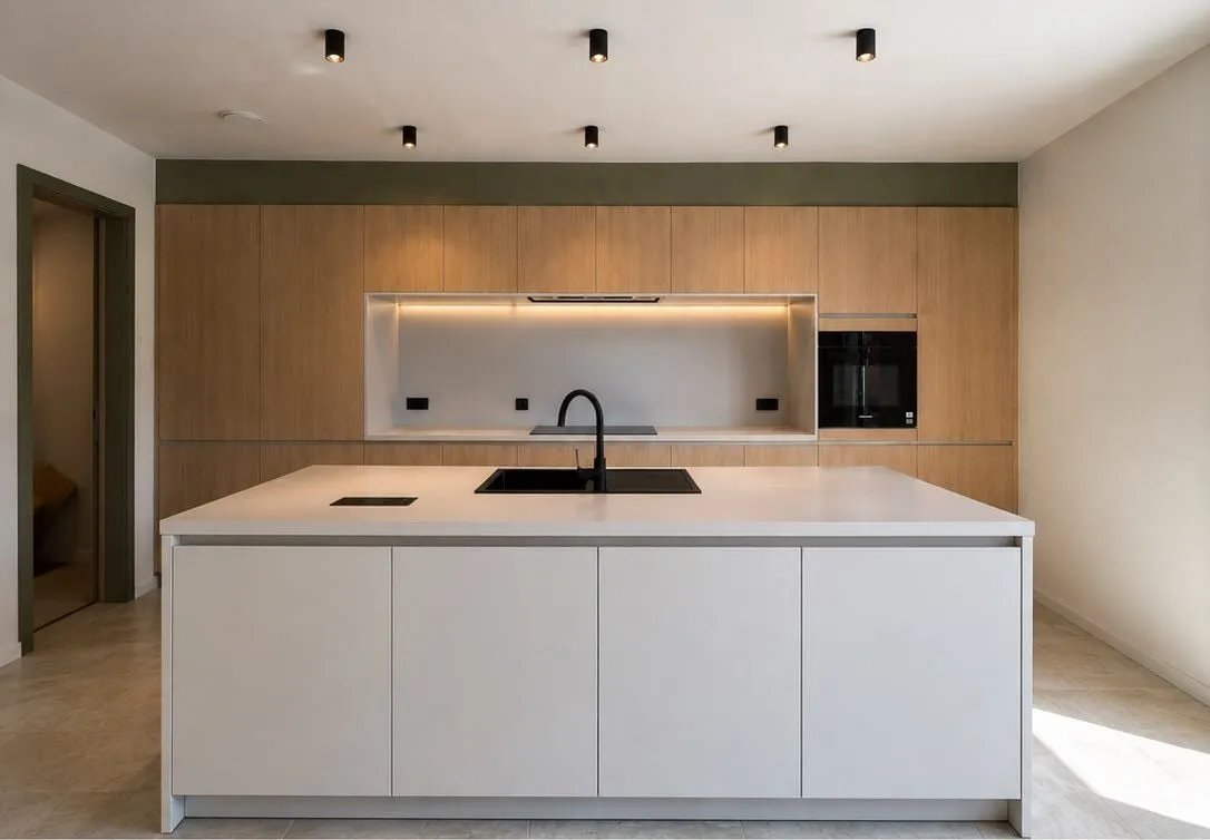 Keuken met een volledige kastenwand en een wit eiland